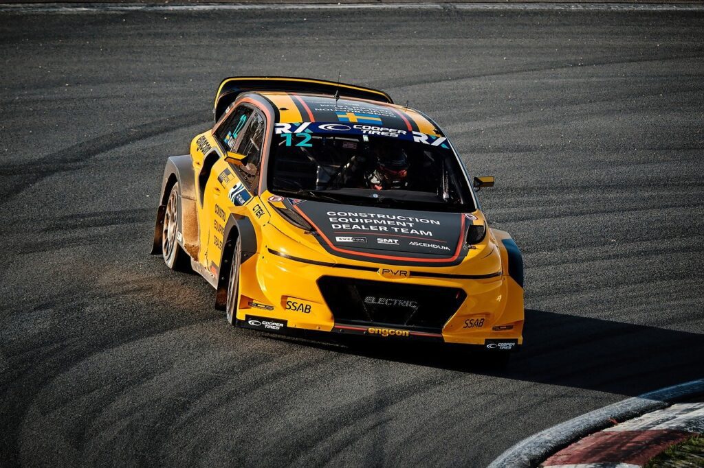 Black and yellow racecar brakes as it drifts around a corner.
