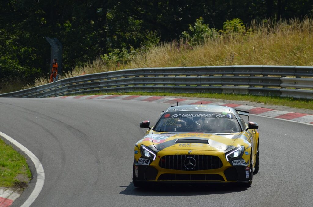 Yellow and black racecar taking a corner on a racetrack.